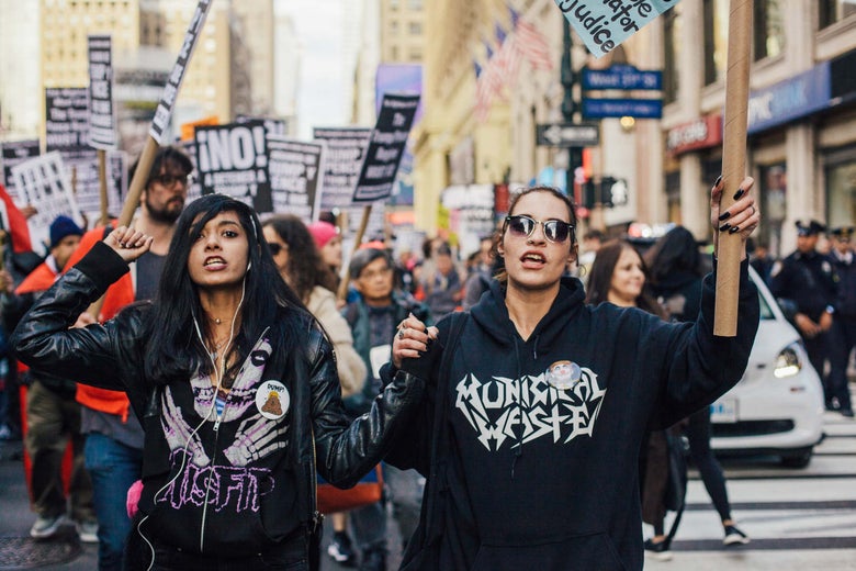 Demonstrators hold signs while marching.